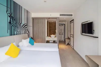 a hotel room with a bed and a television at Kamaniiya Petitenget Seminyak in Seminyak