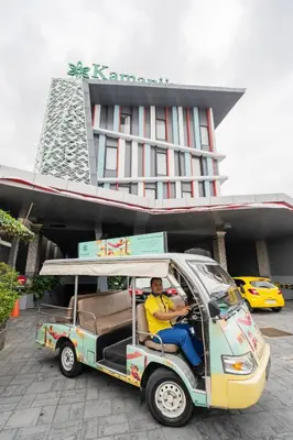 a man sitting in a golf cart in front of a building at Kamaniiya Petitenget Seminyak in Seminyak