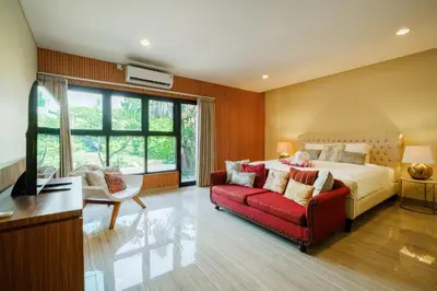 a bedroom with a bed and a red couch at Amelia D Art Deco Suites in Seminyak