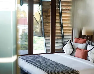 a bedroom with a bed and a window at Dacolina House Jimbaran in Jimbaran