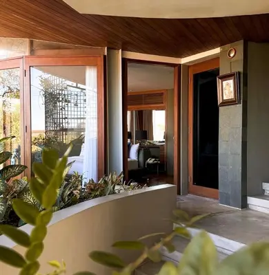 a house with sliding glass doors and a porch at Dacolina House Jimbaran in Jimbaran