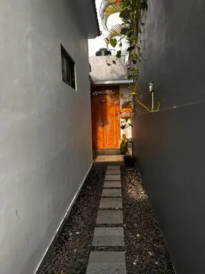a hallway with a wooden door in a building at BEN & B Villa 2 in Kerobokan
