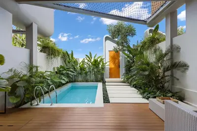 an indoor garden with a swimming pool and plants at Luxury Couple 2 BR Villa Umalas, Rooftop, Pool & View in Kerobokan