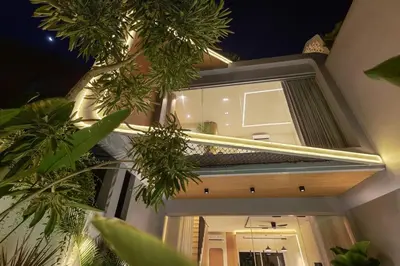 a view of a building at night with palm trees at Luxury Couple 2 BR Villa Umalas, Rooftop, Pool & View in Kerobokan