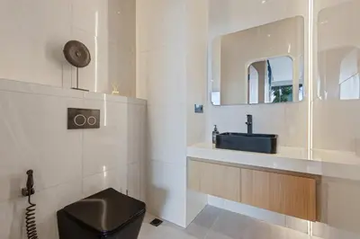 a bathroom with a black toilet and a sink at Luxury Couple 2 BR Villa Umalas, Rooftop, Pool & View in Kerobokan