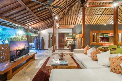 a living room with a couch and a tv at Joglo-Style 3 Bedroom Villa in Heart Of Seminyak in Seminyak