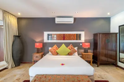 a bedroom with a white bed and two lamps at Joglo-Style 3 Bedroom Villa in Heart Of Seminyak in Seminyak