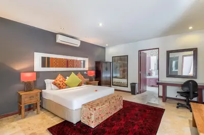 a bedroom with a large white bed and a desk at Joglo-Style 3 Bedroom Villa in Heart Of Seminyak in Seminyak
