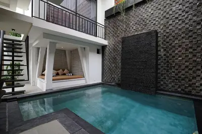a swimming pool in the middle of a house at Cleo Villa Padma Legian in Seminyak