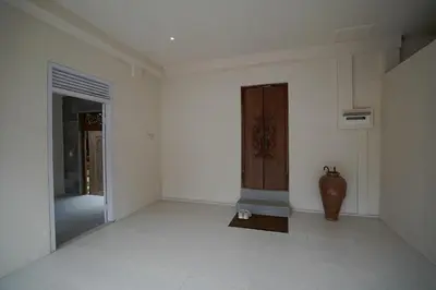 a white room with a door and a vase in it at Cleo Villa Padma Legian in Seminyak