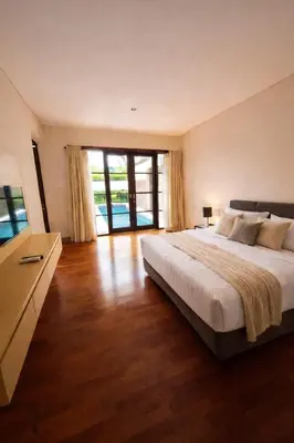 a bedroom with a large bed and a large window at Royal Tulip Springhill Resort Villa Kunyit 12 in Jimbaran