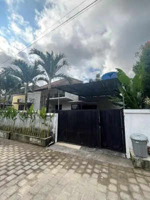 a house with a black fence and palm trees at 2 Bedroom Guest House Near Jimbaran Beach in Jimbaran