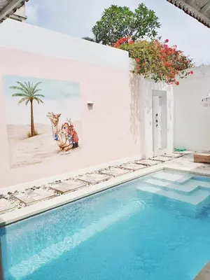 a swimming pool in a house with a painting on the wall at Gypsy Boutique Villa in Seminyak