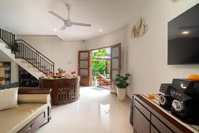 a living room with a couch and a tv at Villa WENDY Mertanadi in Seminyak