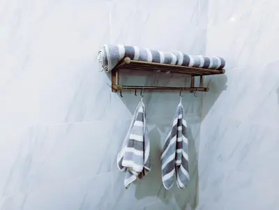 two towels are hanging on a rack in a bathroom at Joy Private Pool Villa in Kuta