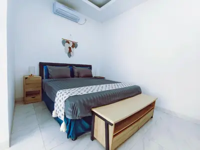 a bedroom with a bed in a white room at Joy Private Pool Villa in Kuta