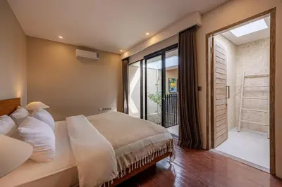 a bedroom with a large bed and a sliding glass door at Villa Arta - A Calm, Tropical Villa in Umalas in Canggu