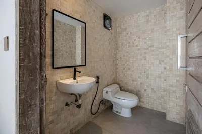 a bathroom with a white toilet and a sink at Villa Arta - A Calm, Tropical Villa in Umalas in Canggu