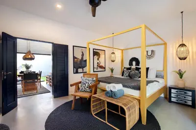 a bedroom with a canopy bed and a living room at Villa Suka Saki Seminyak with pool, wifi, & staff in Seminyak