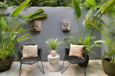 a patio with two chairs and a vase and plants at Villa Suka Saki Seminyak with pool, wifi, & staff in Seminyak