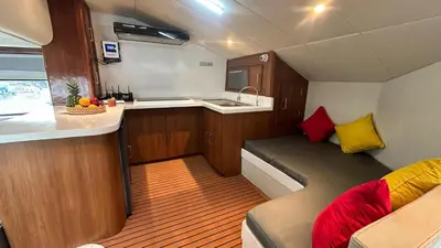 a small kitchen with a couch and a sink in a boat at La Merry Yacht cruise in Pulau Serangan
