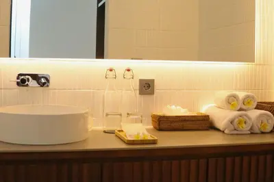 a bathroom counter with a sink and towels at Glenda Cozy 3 BR Private Pool Villa in Canggu