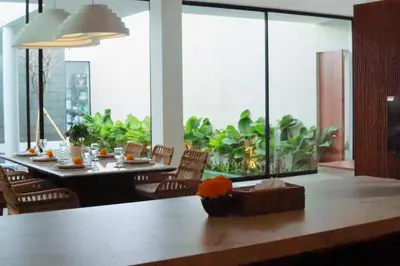 a dining room with a long table and a large window at Glenda Cozy 3 BR Private Pool Villa in Canggu