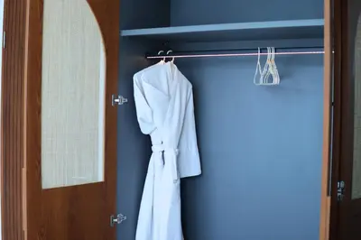 a robe hanging on a rack next to a door at Glenda Cozy 3 BR Private Pool Villa in Canggu
