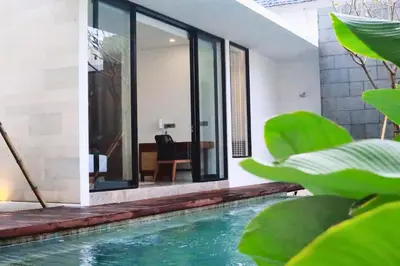 an indoor pool in a house with green plants at Rowena Comfortable 2 BR Private Pool Villa in Canggu