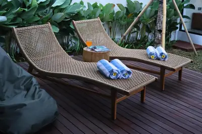 two wicker chairs sitting on a deck with a drink at Rowena Comfortable 2 BR Private Pool Villa in Canggu