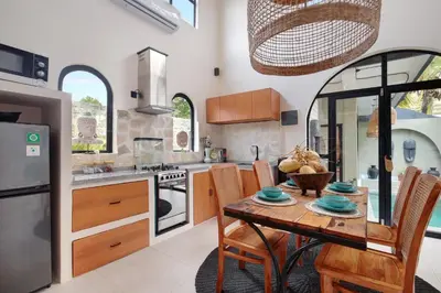 a kitchen with a wooden table with chairs and a dining room at WH18 Luxury Loft Villa with Pool & Office in Seminyak