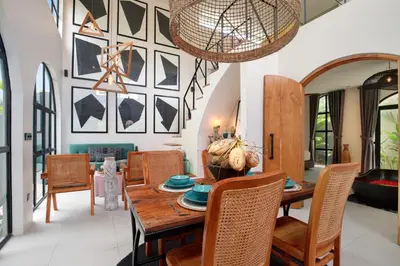 a dining room with a wooden table and chairs at WH18 Luxury Loft Villa with Pool & Office in Seminyak