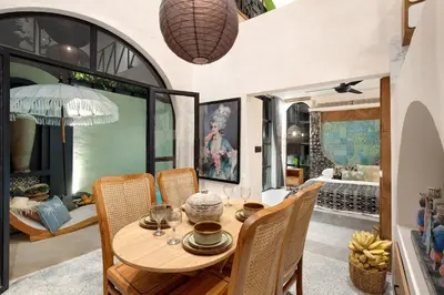 a dining room with a wooden table and chairs at WH18 Luxury Loft Villa with Pool & Office in Seminyak