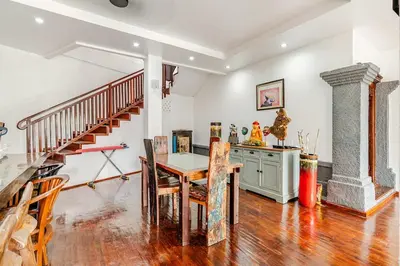 a dining room with a table and a staircase at iVAVev Isus Lucersfera in Seminyak