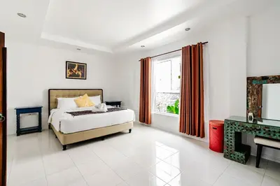 a bedroom with a bed and a fireplace and a window at iVAVev Isus Lucersfera in Seminyak