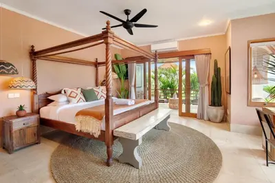 a bedroom with a canopy bed and a fan at 5BR Luxury Berawa Canggu with Butler in Canggu