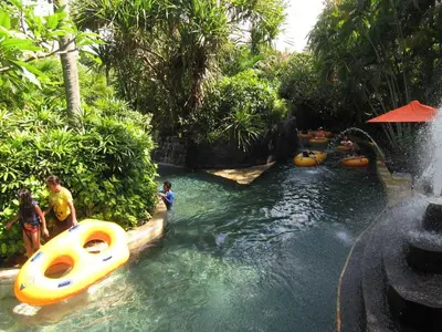 a group of people in a water slide at a resort at DBI Hotel - 1 minute to the Beach and 1 second to the Mall in Ngurah Rai International Airport