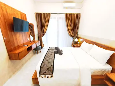 a hotel room with a bed and a tv and a bed sidx sidx at Jepun segara homestay in Ngurah Rai International Airport