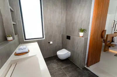a bathroom with a toilet and a sink at Luxury 4BR Villa - Pool Rooftop Berawa Canggu in Balian
