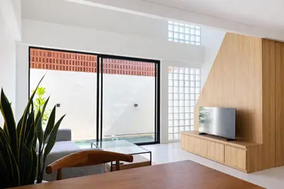 a living room with a glass table and a tv at Private Pool Villa Near Uluwatu in Jimbaran