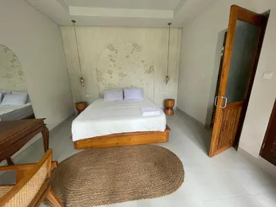 a small bedroom with a bed and a rug at Villa Makna Canggu in Canggu