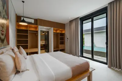 a bedroom with a large bed and a large window at Villa Kalooka by BaliSuperHost in Seminyak