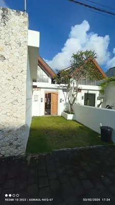 a white house with a tree in the yard at Palm Harmony Villa's Seminyak in Seminyak