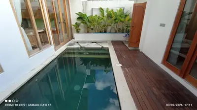 a small swimming pool in a house with a wooden floor at Palm Harmony Villa's Seminyak in Seminyak