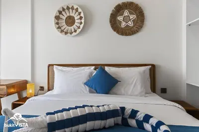 a bedroom with a bed with blue and white pillows at Hummingbird Villa by Bukit Vista in Kerobokan