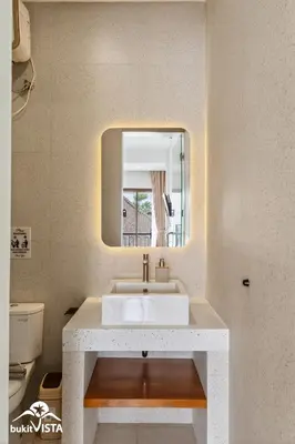 a bathroom with a white sink and a mirror at Hummingbird Villa by Bukit Vista in Kerobokan
