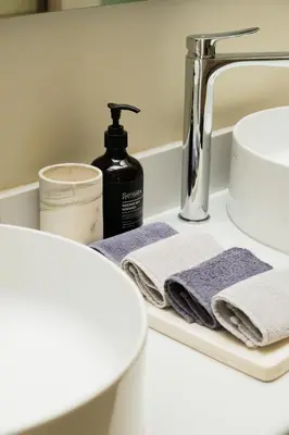 a bathroom sink with towels on a shelf at Private Romantic Pool 1bd Villa in Seminyak in Seminyak