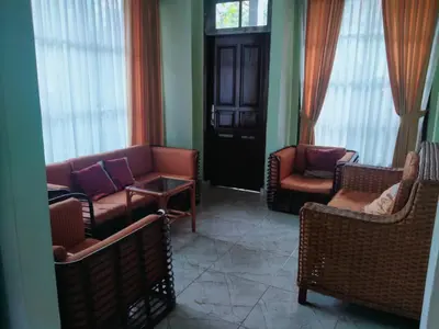 a living room with couches and chairs and windows at Widi House in Nusa Dua