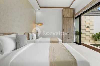 a bedroom with two beds and a large window at Surbiton Villa by Kozystay - Seminyak in Seminyak