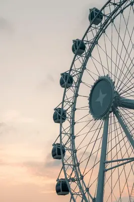 a ferris wheel with a sunset in the background at The Wheel Bali in Canggu